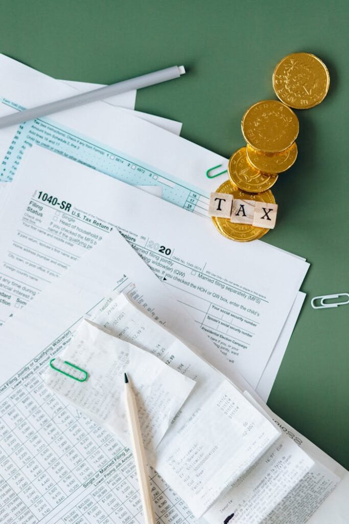 The Art of Drawing Readers In: Your attractive post title goes here Tax documents and gold coins on a green desk symbolizing financial planning and savings.